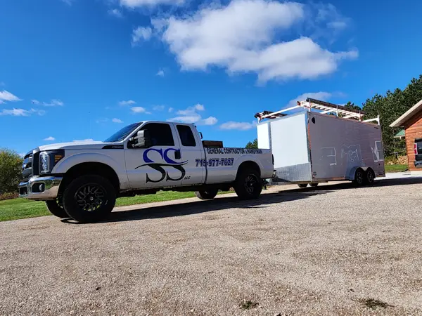 silver Work truck pulling a trailer with SS on the door